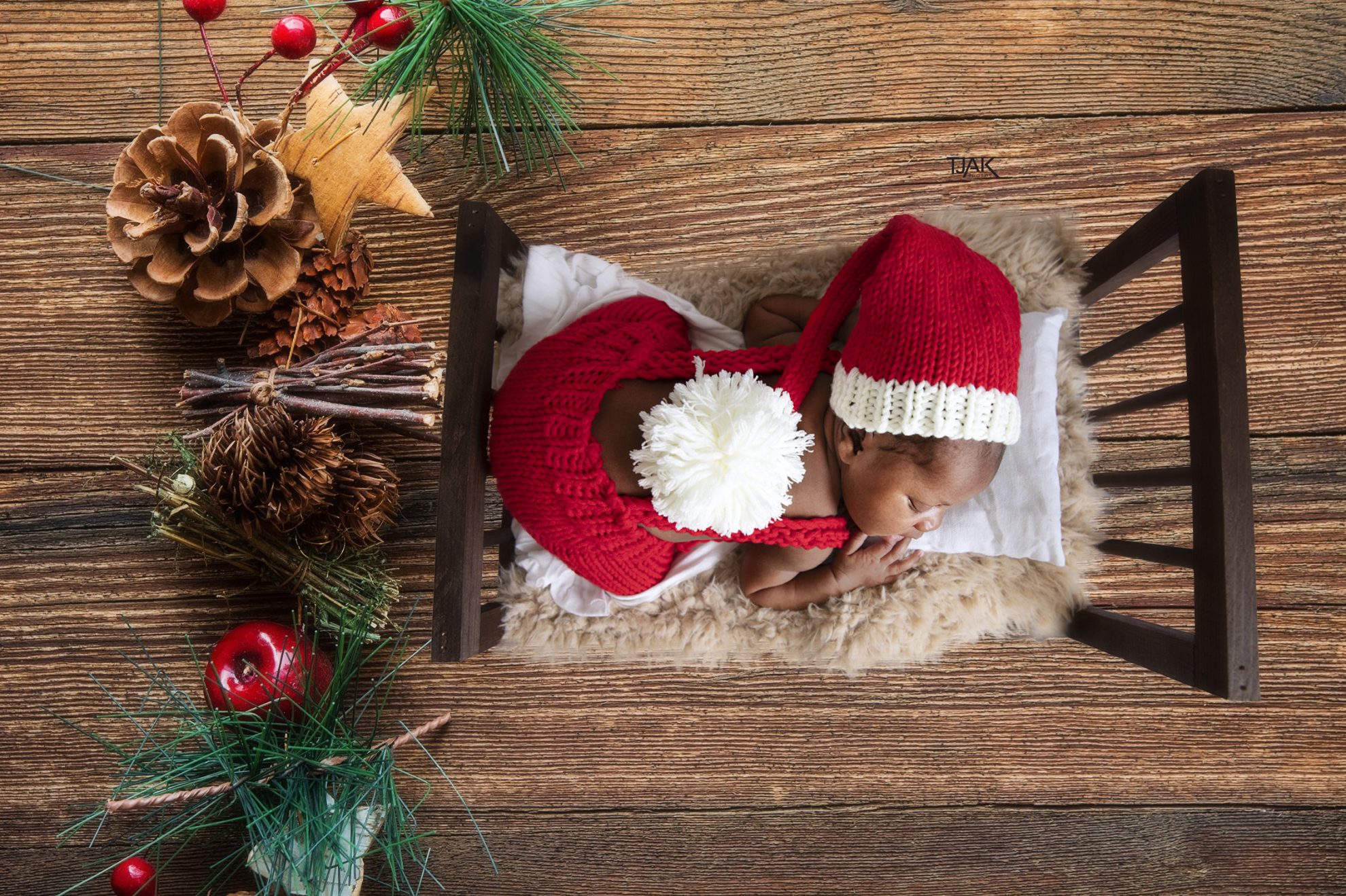baby dressed in Santa's cloth for a newborn photography