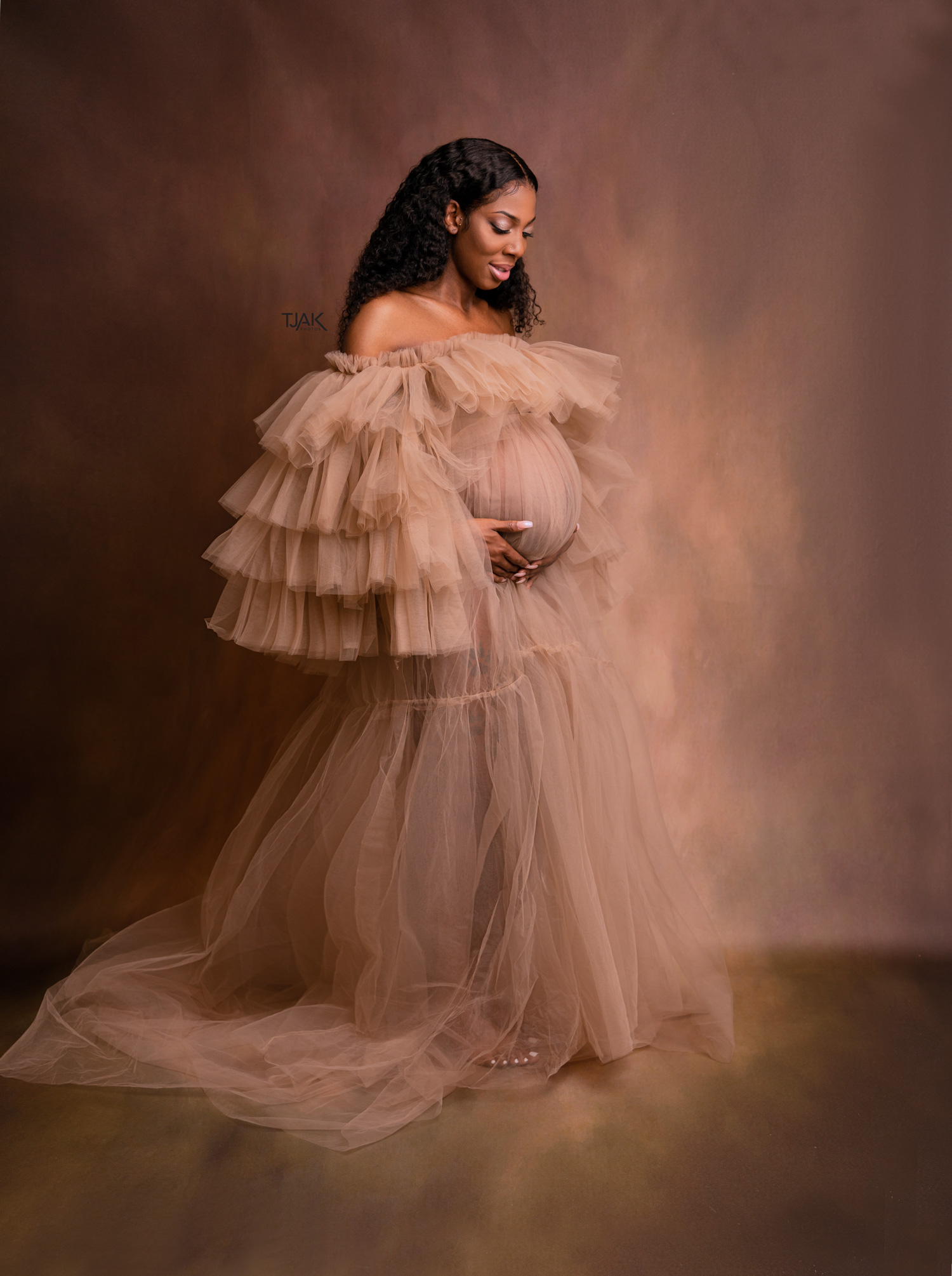 fine art maternity picture of a pregnant woman in a nude tulle dress in a studio in Laurel MD near College Park Maryland