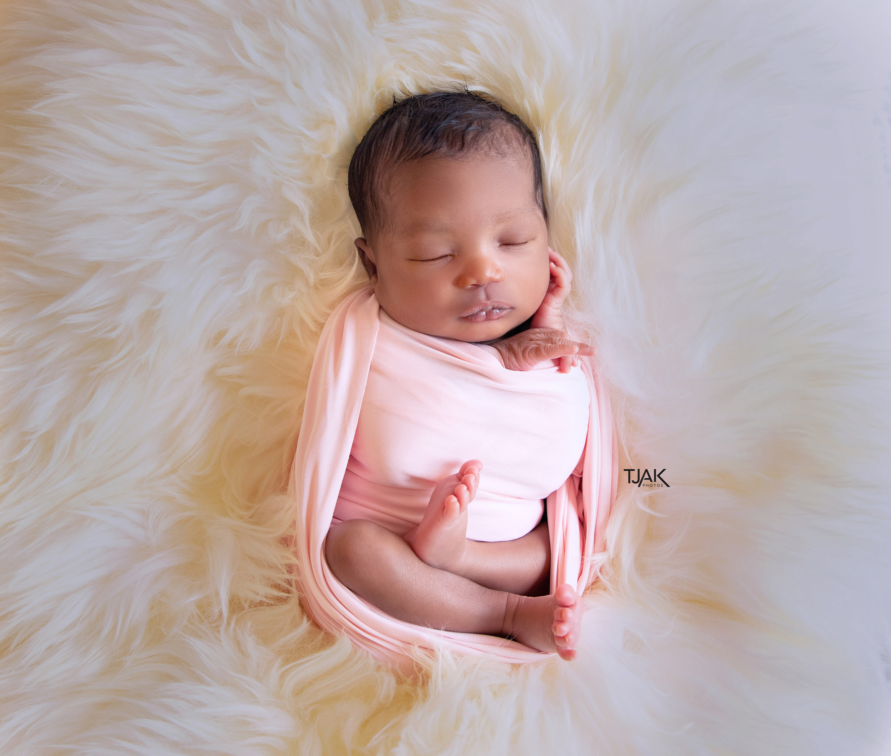 Newborn sleeping on a fur blanket for a newborn photography